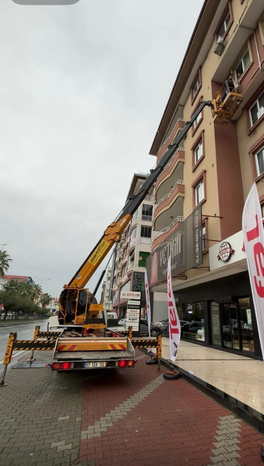 Cadde üzerindeki bina cephesinde sepetli vinç ile yüksekte çalışma