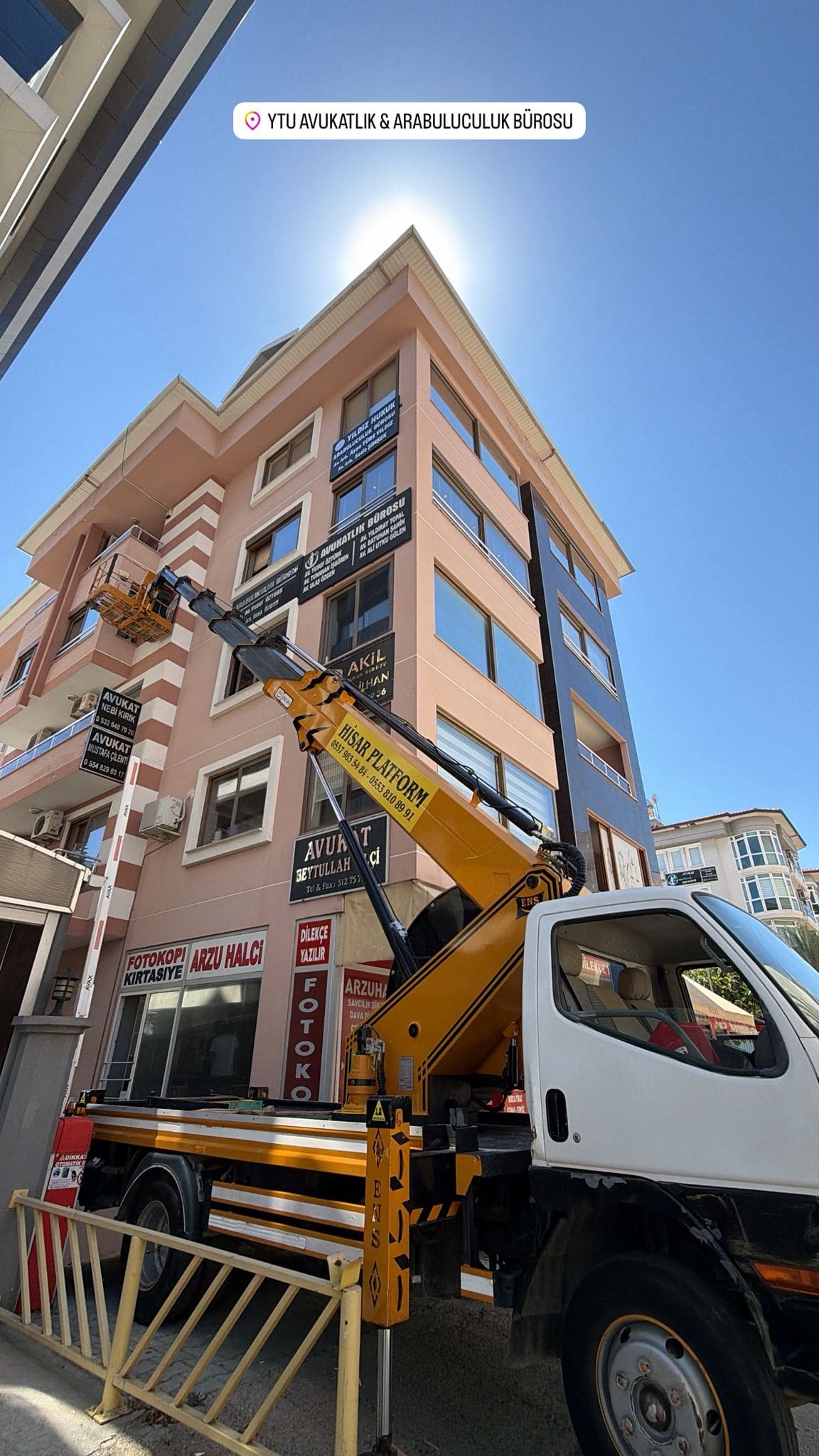 İş yeri tabelaları arasında üst kat penceresine erişen Hisar Platform sepetli vinci